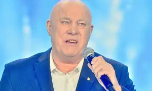Łysy mężczyzna w garniturze trzyma mikrofon. Słychać jego głos: "Vox szczęśliwej drogi już czas!".