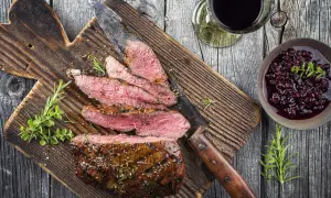 Skivad tagliata med rosmarin och en bärsås, perfekt till ett glas rött vin.