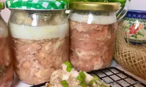 Słoiki z mięsem w galarecie, jeden z zieloną kratkowaną zakrętką, obok kubek i bazylia.