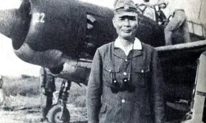 En japansk kamikaze pilot står framför ett flygplan.