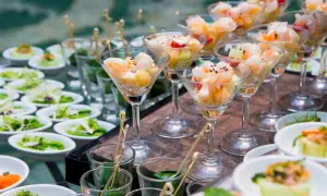 Eleganckie menu na wesele: krewetki z owocami w kieliszkach, sałatki i przystawki w małych miseczkach.