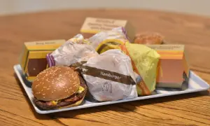 Taca pełna hamburgerów z McDonald's. Widać opakowania Big Mac, McRoyal i inne.