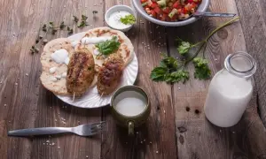 Kebab z płaskim chlebem, sałatką i napojem. Czy to ayran? To orzeźwiający napój jogurtowy, idealny do takiego posiłku.