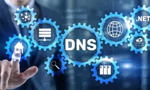 Grafika przedstawia mechanizm zębatek z napisem DNS. Ikony symbolizują dom, wyszukiwanie, serwery i sieć. Dowiedz się, jak sprawdzić DNS.