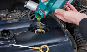 Persona vierte aceite nuevo en el motor. El estado del vehículo influye en su longevidad.