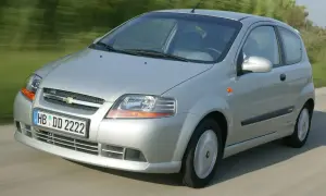 Srebrny Chevrolet Kalos w wersji 3-drzwiowej porusza się po drodze.