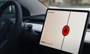 Teslas mittskärm visar "SENTRY ACTIVATED" med en röd ögonliknande ikon. Bilen är redo att agera som en vaktpost.