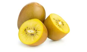 Kiwi amarillo entero y cortado por la mitad, mostrando su pulpa dorada y semillas negras. Descubre sus increíbles kiwi amarillo propiedades.