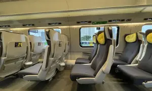 Wnętrze pociągu Pendolino. Fotele klasy 1 i 2, wygodne, z żółtymi zagłówkami, czekają na pasażerów.