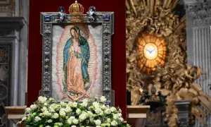 Matka Boża z Guadalupe, jej przesłanie pokoju i nadziei, w otoczeniu kwiatów i ozdobnej ramie, w kościele.