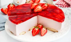 Pyszny sernik na zimno z mascarpone, udekorowany galaretką i świeżymi truskawkami. Idealny na letnie popołudnie.