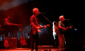 Kiko Veneno y Martirio en concierto, con luces rojas y humo. Kiko toca la guitarra eléctrica, Martirio la acústica.