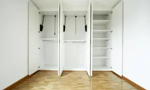 Armadio bianco con ante aperte, barre appendiabiti e ripiani. Ottime idee ripostiglio in cartongesso per organizzare ogni spazio.
