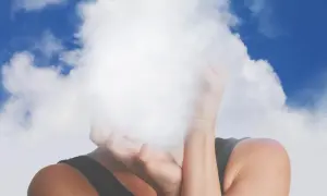 Osoba z twarzą ukrytą w chmurach, symbolizującą mgłę mózgową.
