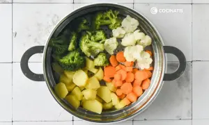 Un vaporizador lleno de un colorido panache de verduras: brócoli, coliflor, zanahorias y patatas cortadas.