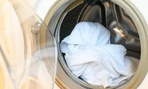 Białe ręczniki w bębnie pralki. Dowiedz się, jak prać ręczniki, żeby nie śmierdziały i były świeże.