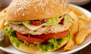 Pyszny fit burger z kurczakiem, awokado i chrupiącymi frytkami. Idealny na zdrowy posiłek.