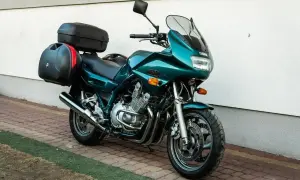 Zielony motocykl Yamaha XJ 900 z kuframi, gotowy na daleką podróż.