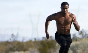 Uomo a torso nudo corre, mostrando i suoi addominali scolpiti. La corsa coinvolge potenti muscoli delle gambe e del core.