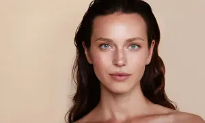 Un maquillage subtil pour agrandir les yeux, mettant en valeur des iris bleus et des taches de rousseur naturelles.