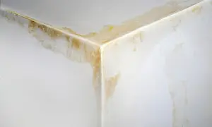 Ecke einer Eigentumswohnung mit deutlichen Wasserflecken und Verfärbungen an Wand und Decke, ein Zeichen für einen unverschuldeten Wasserschaden.