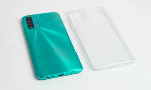 Turkusowy telefon i przezroczyste etui obok. Zastanawiasz się, czym umyć etui od telefonu, by znów wyglądało jak nowe?