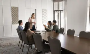 En kvinna presenterar för ett team vid ett konferensbord. Hon förklarar vad cto betyder för dem.