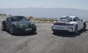Dwa Porsche 911 GT3, zielone i białe, stoją na górskiej drodze.