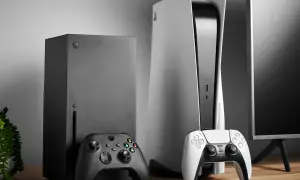 Konsola Xbox Series X i PlayStation 5 z kontrolerami na drewnianym stole.