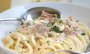 Cremige Nudeln mit Thunfisch, garniert mit Petersilie und Parmesan. Ein köstliches Gericht, das Lust auf mehr macht.