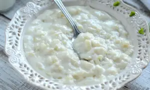 Pyszna, kremowa zupa mleczna z ryżem, podana w ozdobnej miseczce. Idealna na śniadanie lub deser.