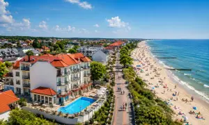 Fajny hotel nad morzem z basenem i widokiem na plażę pełną turystów. Idealne miejsce na wakacje.