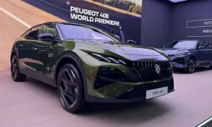 Nowy Peugeot 408 w kolorze zielonym prezentuje się na premierze światowej. Obok stoi jego granatowy brat.