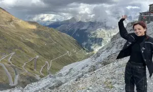 Uśmiechnięta motocyklistka na tle serpentyn w Alpach. Niesamowita przygoda na alpy motocyklem!