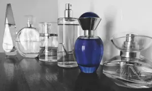 Rząd flakonów perfum, w tym Chanel i niebieski flakon, budzi pytanie: czy perfumy są szkodliwe?