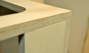 Fragment drewnianego blatu i boku stołu, pokazujący warstwy sklejki. Idealny materiał, by dowiedzieć się, jak zrobić stół drewniany.