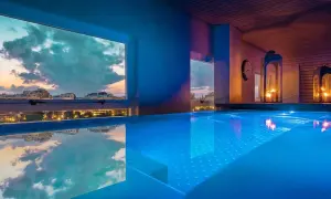 Piscina iluminada con vistas al atardecer de la ciudad. Un lugar perfecto para un día de spa en Valencia.