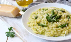 Un crémeux risotto asperges, parsemé de parmesan râpé et garni de jeunes pousses vertes. Un délice printanier.