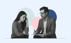 Kobieta z ręką na czole podczas sesji, gdzie terapeuta z notatkami wspiera ją. Terapia integracyjna pomaga odnaleźć spokój.