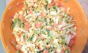 Bunter Salat mit Porree, Karotten und Mais in einer orangen Schüssel. Ein frischer Genuss!