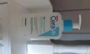 Biała butelka żelu do mycia CeraVe SA z niebieskim dozownikiem na białym tle.