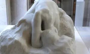 Kamienna postać pochylona w głębokiej zadumie, jak Auguste Rodin Myśliciel, wpatruje się w otchłań własnych myśli.