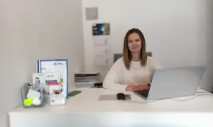 Kobieta przy biurku z laptopem i dokumentami.