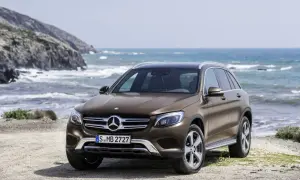 Brązowy, używany Mercedes GLC z salonu na tle morskiego krajobrazu. Idealny na wakacyjne wyprawy.