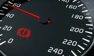 Tableau de bord d'une voiture avec le voyant frein à main reste allumé. L'aiguille du compteur de vitesse indique 60.