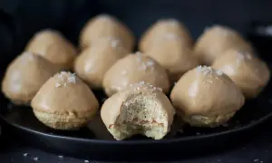 Små, karamellglaserade biskvier med flingsalt, ett läckert biskvier recept. En är uppäten och visar det fluffiga inkråmet.