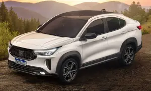 Bianca Fiat Fastback 2026 con tetto nero, su strada sterrata tra alberi e montagne al tramonto.