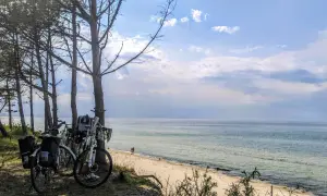 Rowerowe wycieczki to jedne z najlepszych mrzeżyno atrakcje. Rowery zaparkowane przy plaży, morze i niebo.