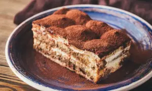 Pyszny kawałek tiramisu na talerzu, posypany kakao. Zastanawiasz się, jaki alkohol do tiramisu nada mu idealny smak?