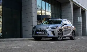 Elegancki, srebrny Lexus RX 350h zaparkowany przed nowoczesnym budynkiem z przeszkloną fasadą.